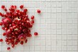 Fresh pomegranates arranged on a clean white tiled surface, perfect for food and nutrition concepts