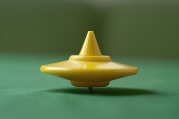 Poster - A yellow toy sitting on a green surface, suitable for various creative projects
