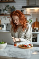 Aufkleber - Woman sitting at a kitchen counter using a laptop. Suitable for technology and work from home concepts