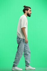 a man, full-length, on a green background, is walking