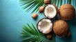   A table holds several coconuts with a green palm leaf nearby The backdrop is a blue wall