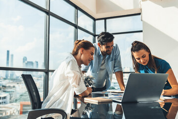 Group of diverse profession business people pointing at laptop displayed idea. Portrait of business team show marketing strategy present by laptop with statistic document scatter on table. Tracery.