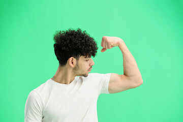 Wall Mural - A man, on a green background, close-up, shows strength