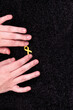 Hands placing a yellow ribbon pin on fabric, the international symbol of advocating for the return of hostages and raising awareness for cancer (specifically sarcoma) support and solidarity.