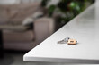Keys with house shaped keychain on table on living room interior background. Concept of new homeownership, renting or leasing a property, and the process of purchasing a home, mortgage arrangements.