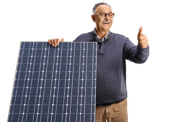 Wall Mural - Mature man behind a solar panel smiling and gesturing thumbs up