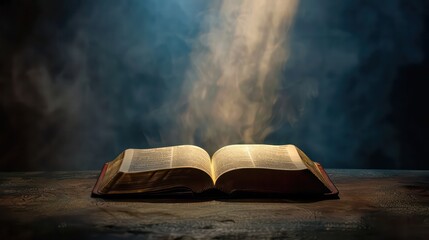 Open bible on a dark background with rays of light and smoke
