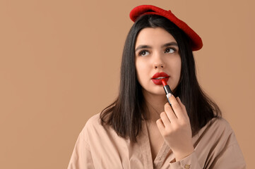 Poster - Beautiful young woman with red lips and lipstick on brown background