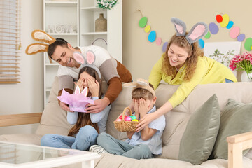 Wall Mural - Parents surprising their children with Easter eggs and cake in room