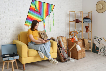 Canvas Print - Young woman writing text YARD SALE in room of unwanted stuff