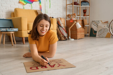 Canvas Print - Young woman writing text YARD SALE in room of unwanted stuff