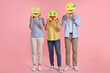 © New Africa - People covering faces with emoticons on pink background