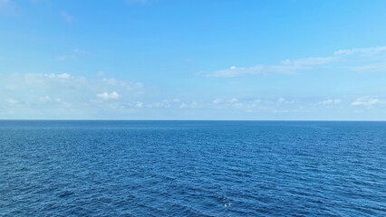 Wall Mural - aerial voyage over boundless azure waves, with a backdrop of cerulean sky and billowing clouds, evok