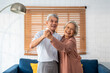 Portrait of Asian senior couple dance together in living room at home. 