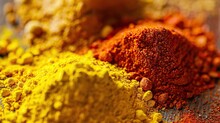There Are Three Piles Of Colorful Spices On A Wooden Table. The Spices Are Turmeric, Chili Powder, And Paprika.