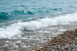 Closeup view of the water's edge on beach shore, seaside, pebbles and waves