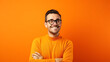 A cheerful millennial man wearing glasses, hands folded, on a bright orange backdrop
