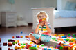 Child playing with colorful toy blocks. Kids play.