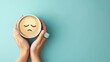 © Katrin_Primak - Female hands holding coffee cup with sad smiley latte art. Depression and sadness concept