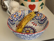 Bunch of Ripe Yellow Bananas inside a Hand Painted Ceramic Pottery Bowl in the Kitchen