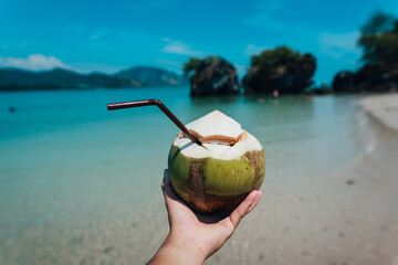 Wall Mural - coconut in hand at the beach on a summer day