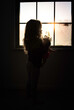 © Cavan Images - Toddler looking out frosty window while holding toy
