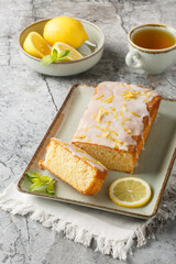 Wall Mural - Lemon Drizzle Cake has a crunchy sugar glaze that crystallizes on top closeup on the plate on the table. Vertical