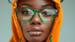 © Nataliia_Trushchenko - A African American woman wearing green glasses and an orange hoodie. The woman has a serious expression on her face. Portrait up of a female African American wearing a high-en fashion orange hoodie