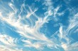 Wispy clouds floating peacefully against a backdrop of clear blue sky