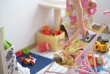 Fototapeta  - little girl playing at home, touching stuffed animal in colorful environment