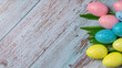 Tulip flowers and easter eggs on grey planked wooden background. Top view from above	