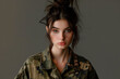 © Enrique - Studio portrait of a young female model wearing trendy fatigues. Dark hair in oose hair bun