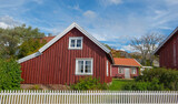 Fototapeta  - red typical house with white fence in front in a sweden village