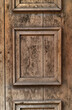 part of an old wooden entrance door in front with decorative frames