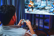 Focusing photo of holding joystick with fighting gaming competition of video game on blurred monitor screen. Controlling the button of joypad. Concept of lifestyles gamer in living room. Sellable.