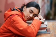 Sleeping, books and woman at table in library for education, tired or exhausted from studying. School, female person and university student for fatigue, rest or burnout for college examination
