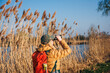 Bird watching. Woman with binoculars looking for wildlife animals and birds at lake