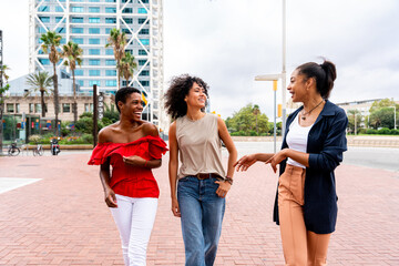 Wall Mural - Three mixed race hispanic and black women bonding outdoors