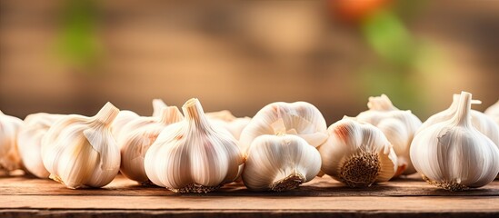 Wall Mural - Several garlic bulbs on wooden surface with blurred backdrop