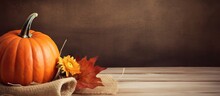 Pumpkin And Fall Foliage On Wooden Surface