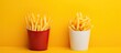 Two crispy fries on vivid yellow backdrop