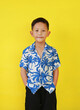 Portrait of Asian boy in summer dress costumes according to Thai culture to celebrate the Songkran festival of people on Thailand New Year on yellow background.