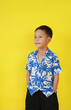 Asian boy in summer dress costumes according to Thai culture to celebrate the Songkran festival of people on Thailand New Year on yellow background.