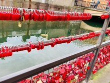 Many Red Love Locks On A Mesh Fence On A Bridge In Colmar France.