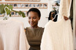 © peopleimages.com - Retail, shopping and black woman in store, customer and choice in show room or boutique. Purchase, fabric and thrift clothing for eco friendly and sustainable buying, smile or female consumer in mall