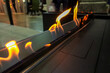 A bio-ethanol fireplace burns with orange flames in a dark room.