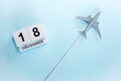 December calendar with number  18. Top view of a calendar with a flying passenger plane. Scheduler. Travel concept. Copy space.