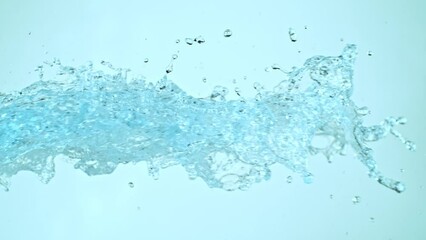 Wall Mural - Super Slow Motion of Flying Water Splashes, Isolated on Blue Background. Filmed on High Speed Cinema Camera, 1000fps.