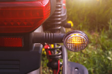 The Right Turn Signal Of Scooter Or Bike Parked On The Roadside. The Closeup View Of Direction Safety Signal With Outdoors Summer Environment.