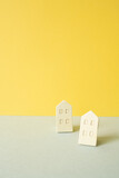 Fototapeta Londyn - Wooden house model on gray and yellow background. Real estate concept